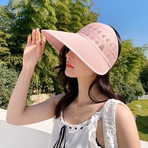 Détail de la visière pare-soleil en tricot rose clair avec logo M et motif ajouré