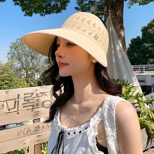 Détail d'un chapeau de soleil en maille beige avec crochet ajouré et logo en métal