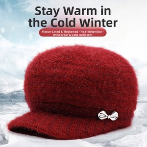 Close-up of winter knit hat with plush texture and silver bow detail in snowy setting
