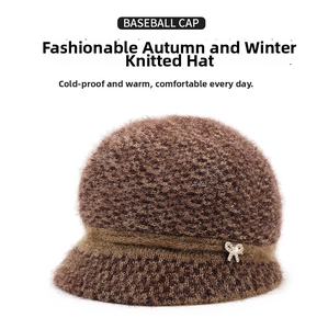 Detailed close-up of dark brown knit hat with decorative bow and pearl accent