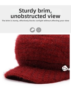 Detail of a red winter knit cap with a stiff visor and elegant silver heart metal button