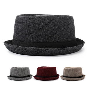 Detail of checkered fedora hat with breathable fabric texture and black decorative band