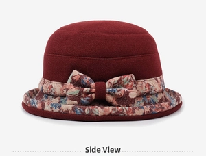 Detail view of burgundy winter hat showing side bow and vintage floral pattern fabric