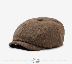Side view detail of a brown newsboy cap with vintage textured woven fabric and peak