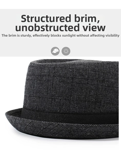 Close-up of the dark gray plaid fabric texture and black decorative band on this jazz hat
