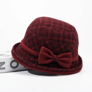 Macro detail of wine red plaid bucket hat with bow accent on a minimalist display
