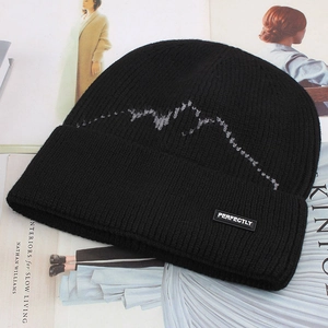 Detail of black winter knit beanie with grey mountain pattern and PERFECTLY logo patch