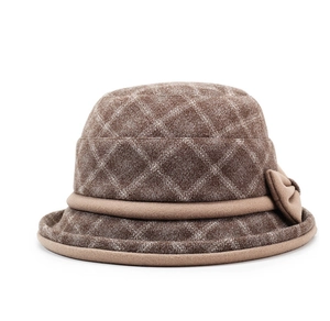 Close-up of brown plaid wool cloche hat featuring diamond patterns and a decorative bow