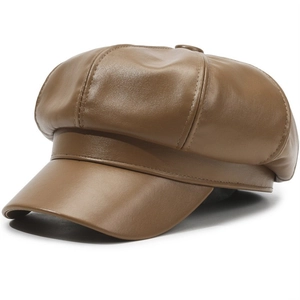 Detail of premium brown PU leather flat top beret with fine lychee grain texture