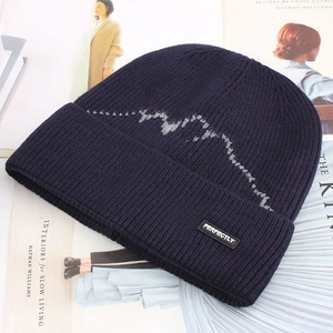 Close-up of navy blue winter beanie with knitted pattern and 'PERFECTLY' logo tag