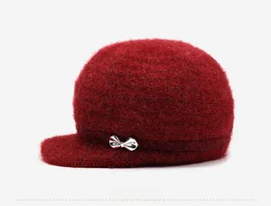 Detail view of red knit peaked cap with fluffy faux mohair texture and silver bow detail