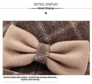 Detail of wool bucket hat featuring a brown plaid pattern and elegant camel bow decoration