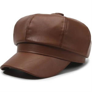 Detail view of dark brown leather baker boy hat showing textured panels and fine stitching