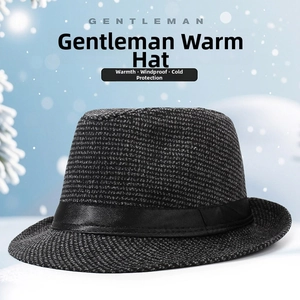 Detail of dark grey fedora with black leather band against a snowy winter backdrop