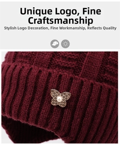 Detail of burgundy knitted winter hat featuring a butterfly pearl ornament and crystal accents