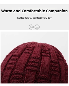 Detail of burgundy knitted hat showing thick textured square patterns and warm fabric