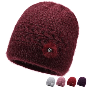 Dettaglio ravvicinato del berretto in maglia bordeaux con filato glitterato e decoro floreale