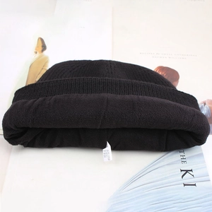 Detail view of winter beanie showing thick black fleece lining and soft knit texture
