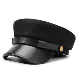 Détail de la casquette noire en tissu texturé avec visière en cuir et bouton métallique