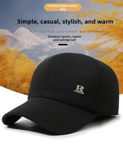 Detail von winddichtem Stoff und Metall-Logo an einer Thermomütze für Herren im Winter
