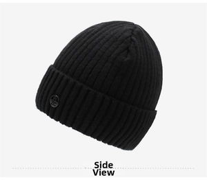 Detail showing black ribbed knit beanie with round decorative side badge for winter