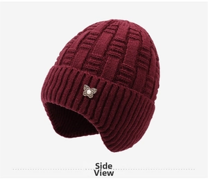 Close-up of wine red knit hat with butterfly pearl ornament and basketweave texture