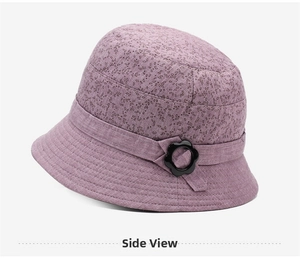 Detail view of purple floral bucket hat featuring a decorative black petal buckle on the side