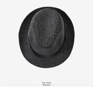 Top view of a black-grey wool fedora hat with a black satin ribbon on a grey background