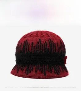 Close-up of burgundy knitted winter hat with floral detail and warm fleece lining
