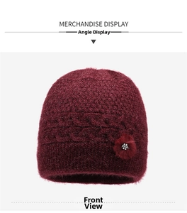 Vista dettagliata di un cappello invernale in maglia rosso scuro con fiore di strass