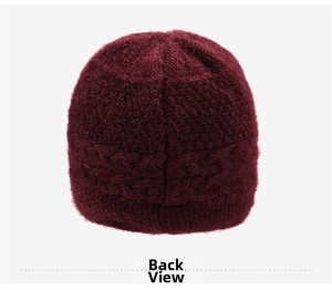 Dettaglio del cappello in maglia bordeaux scuro con motivo a trecce e riflessi brillanti
