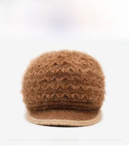 Detail of a brown knit hat with textured scales and sparkling 'LOVE' rhinestone accessory