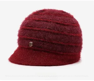 Dettaglio del cappello in maglia bordeaux con trama morbida e spilla di cristalli