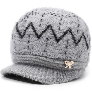 Grey knit winter hat for women with ear protection and a gold bow pearl detail