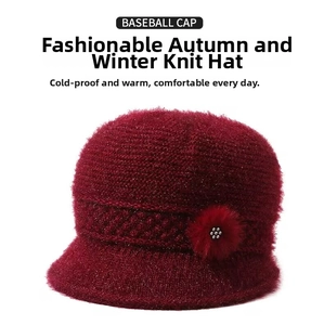 Detail of dark red knit winter hat with elegant faux fur flower and white bead accent