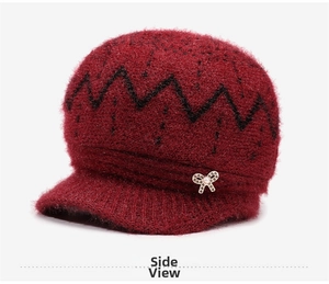 Detail of wine red knit hat with fuzzy texture, brim, and elegant pearl bow brooch