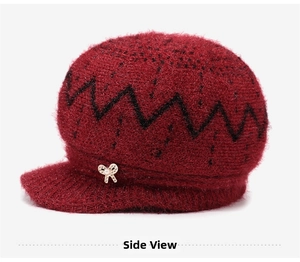 Detail of dark red knit hat with fuzzy texture, black wavy patterns and pearl bow pin