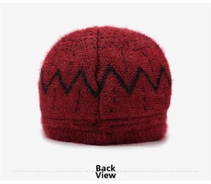 Detail view of the plush red knit hat featuring a black zigzag pattern and soft texture
