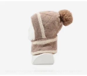 Détail de l'écharpe à capuche en tricot d'hiver avec pompon et motif losanges texturé