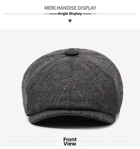 Detail of dark grey herringbone newsboy cap with red plaid stitching and top button