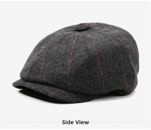Detail view of dark grey herringbone newsboy cap with red windowpane check pattern