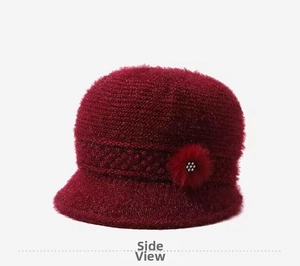 Detail of wine red knit winter hat with plush flower and white pearl decoration