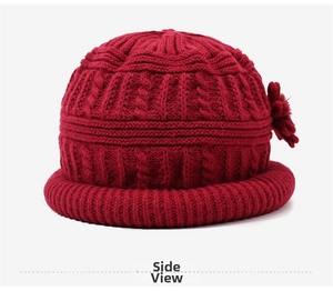 Detailed knit texture and floral accent on a warm dark red winter hat for elderly women