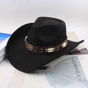 Detail of black wool cowboy hat featuring bull head metal badge and beaded band decor