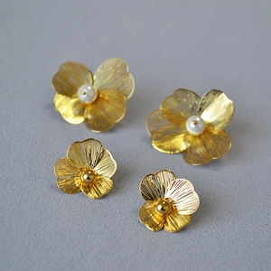 Detail of 925 silver needle double-layered flower earrings with pearls and gold beads