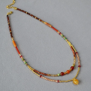 Double-layered beaded necklace with colorful stones and a yellow teardrop pendant