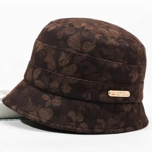 Detailed view of brown felt bucket hat featuring butterfly pattern and gold metal tag