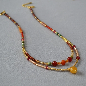 Double-layer beaded necklace featuring vintage stones in red, green and amber tones