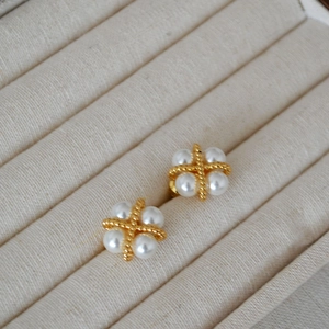 Vue macro détaillée des boucles d'oreilles trèfle plaquées or avec perles élégantes