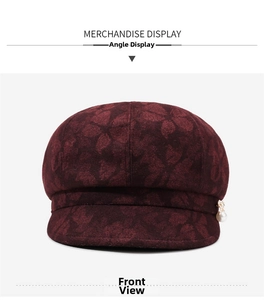 Detailed view of dark burgundy newsboy hat with floral jacquard texture and pearl detail